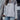 Woman wearing a gray pullover with a leopard print quilted half-zip design, showcasing chic streetwear style.