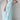 Woman wearing a light blue ruffle sleeve tiered maxi dress showcasing a summer fashion style.