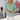 Light blue V-neck split sleeve button-front blouse for women, displayed on a mannequin with a plant in the background.