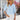 Woman wearing light blue V-neck split sleeve button-front blouse with elegant design.