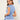 Woman wearing light blue V-neck twist-front blouse with short sleeves.