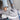 Light grey women's fashion sneakers made of breathable mesh with a cushioned sole.