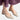 Black leather women's low-heel minimalist flats being worn, showcasing comfort and style with a focus on the foot and leg positioning against a floor background.