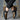 Luxury black leather men's formal shoes with a designer checkered pattern, worn by a person dressed in formal attire.