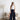 Elegant two-tone luxury designer tote bag for women, featuring a sophisticated fashion design on a grey textile background, displayed against a wooden flooring.