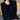A woman wearing a black, high-quality cashmere sweater, featuring a dress shirt collar and long sleeves.