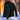 Men's black insulated waterproof winter jacket with long sleeves, designed for thermal protection in snowy and freezing conditions, displayed outdoors with trees in the background.