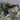 Men's military camo style jacket featuring a camouflage pattern in shades of grey, khaki, and beige with long sleeves and a collar, designed for tactical outerwear.