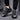 Men's grey futuristic design sneakers displayed on a human foot, showcasing urban athletic style and contemporary fashion trends.