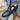 Men's luxury brown leather loafers with a buckle, formal slip-on shoes displayed on a person wearing a blue blazer and denim pants.