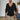 A man wearing a black slim fit V-neck thermal knit sweater in an XL size, showcasing the earth tone design. The sweater features long sleeves and is styled for a fitted appearance.