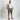 Men's white linen short sleeve casual shirt worn by a person, showing lightweight and breathable fabric.