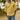 Men wearing a yellow linen shirt with a tailored fit, featuring a classic collar and long sleeves, standing outdoors near greenery.