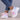 A pair of multicolor women's breathable lightweight athletic sneakers with a design featuring shades of grey, pink, and aqua, worn on a person standing against a white background.