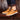 Navy blue men's low-top leather sneakers worn by a person dressed in denim jeans, showcasing a stylish and casual look.