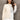 Neutral tone color-block sweater worn by a smiling woman, featuring long sleeves and a stylish neckline, showcasing trendy women's fall knitwear.