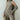 Neutral-toned women's fall outfit featuring a ribbed sweater with long sleeves and matching trousers, highlighting a sophisticated and elegant style.