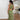 Olive green crochet one-shoulder maxi dress featuring intricate bohemian patterns, highlighting the shoulder and neckline with a fitted waist and flowing design that elegantly drapes to the thighs.