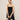 Oversized straw tote bag with a sleek black handle, showcased alongside a model wearing a one-piece garment, highlighting the eco-friendly fashion accessory.