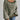 Oversized green striped knit sweater with a cozy boat neck pullover style, worn by a person visible from the shoulders down, paired with jeans.