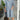 Elegant women's mid-length spring dress in gray, size 3XL, with a casual and lightweight design, featuring a smiling woman showcasing the shoulder area; a plant and flowerpot in the background add a touch of nature and brightness.