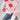 A pink floral lightweight knit sweater featuring a red flower pattern, styled as a pullover. The sweater is paired with blue jeans, highlighting the casual yet stylish look. The sweater is in size XL, with long sleeves and a comfortable fit.