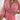 Woman wearing a pink floral V-neck midi dress with a cinched waist, showcasing casual summer fashion.
