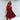 A woman wearing a pink linen tiered mini dress that is sleeveless with a V-neck design, suitable for summer fashion. She has styled hair and is accessorized with sunglasses. The dress has a fitted waist and flows into a mini-length, showcasing a casual and stylish day dress look.