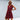 A woman wearing a wine red sleeveless v-neck tiered mini dress made of linen, suitable for summer fashion. She accessorizes with sunglasses and is captured from the shoulders down, highlighting the dress's flowy design and comfortable fit in an outdoor setting.