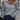 A gray ribbed high-neck slim fit sweater designed for women's streetwear style, featuring long sleeves and a snug fit around the waist, paired with jeans.