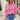 Pink textured ribbed sweater featuring a stylish cut-out design, displayed on a mannequin. The knitwear showcases long sleeves and a high neckline, highlighting the modern fashion-forward design in an XL size.