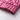 Pink women's lightweight quilted jacket with a diamond pattern, displayed on a couch with decorative pillows in the background.