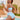 Plus size black crochet halter bikini set featuring a high-waisted design, worn by a smiling woman by the water under a clear blue sky, accessorized with sunglasses.