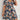 Plus size blue floral tropical print knee-length summer dress worn by a woman standing outdoors with visible plants in the background.