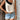 Women's chic fashion polka dot sleeveless summer blouse with contrast collar, featuring black and white design, shown on a model wearing black shorts.