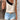 Women's chic fashion sleeveless summer blouse with polka dots and contrast collar in black and white.