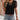 Woman wearing a Polka Dot V-Neck Sheer Sleeve Blouse, styled for a casual chic summer look, with white and black polka dots, visible shoulder and arm details.