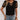 Woman wearing a black polka dot V-neck blouse with sheer sleeves, paired with white shorts, showcasing a casual chic summer style.