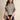 A fashion model wearing a red cable knit sweater with a luxurious textured design, featuring a round neck, long sleeves, and a fitted waist.
