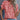 A woman wearing a red floral V-neck summer blouse with short sleeves, paired with jeans.