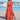 A woman wearing an orange XL maxi beach dress with a side slit, standing outdoors with a clear sky in the background. The lightweight summer dress features short sleeves and a comfortable fit around the waist.