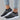 Women's rhinestone black slip-on mesh sneakers, featuring a stylish design with sparkling rhinestones on the upper, shown on a white background. The sneakers are designed for comfort and fashion, suitable for casual wear.