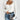 A white ribbed square neck top paired with high waist denim jeans, styled with a mini bag. The top has long sleeves and a fitted design, emphasizing the shoulders and waist.