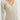Ribbed V-Neck Cream Maxi Sweater Dress showcasing long sleeves and a form-fitting silhouette, emphasizing the shoulder and arm details. The dress is styled for fall fashion and is displayed in a neutral cream color, resembling a blend of white and grey tones.