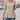 A beige ribbed women's tunic sweater in size 2XL, featuring button details on the knit top, styled casually.