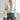 Cream ruffled blouse with a unique neckline in a boho chic and vintage-inspired style, featuring long sleeves and a relaxed fit, paired with jeans.
