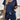 Marine blue ribbed knit top in a 2XL size, showcasing a casual summer style. The top features a ribbed texture and is paired with black shorts, worn by a person who is standing with arms visible. The background includes white cabinetry.