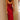 Rust satin midi slip dress featuring a backless design with tie-back detailing, elegantly worn by a woman. The dress showcases thin shoulder straps and gracefully falls to a midi length.