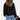 Women's black corduroy jacket with a sherpa lining, featuring a collar and long sleeves, designed as an insulated winter coat.