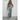 Shimmery silver strapless metallic jumpsuit designed for evening party wear, featuring a sleek one-piece garment style, being modeled by a smiling individual with an elegant hairstyle, showcasing the outfit's fit on the arms, shoulders, and legs.